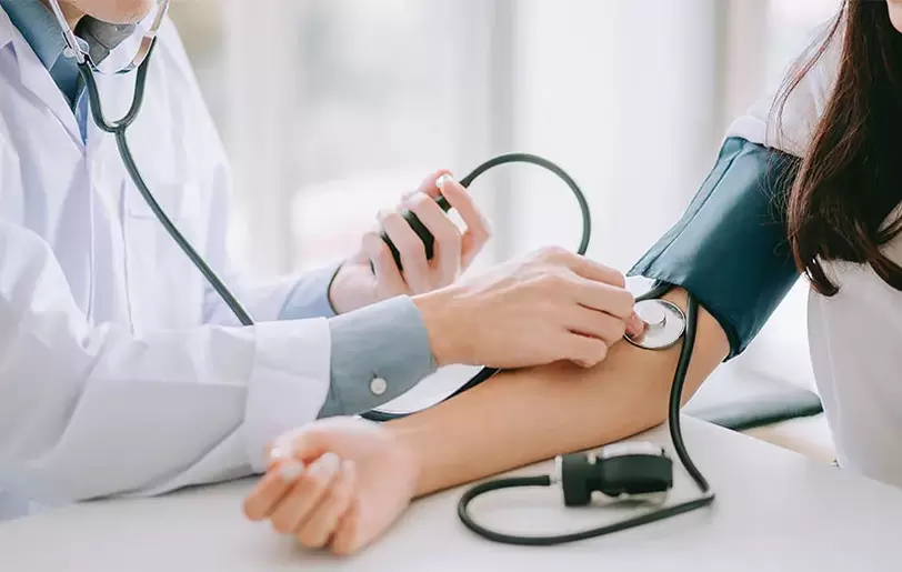 Un cardiologue mesure la tension artérielle d'un patient pour diagnostiquer une hypertension artérielle. 